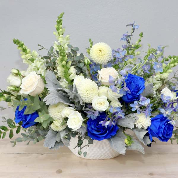 Blue and white floral arrangement in a white vase