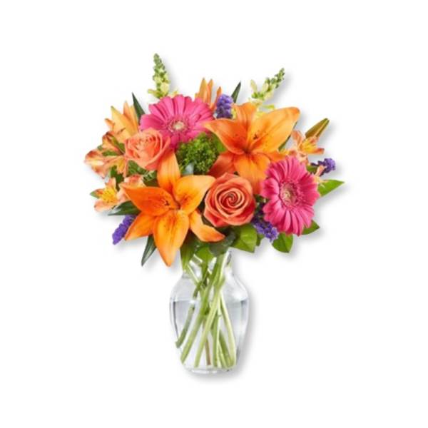 Bright mixed bouquet of orange lilies, pink gerberas, and roses in a glass vase