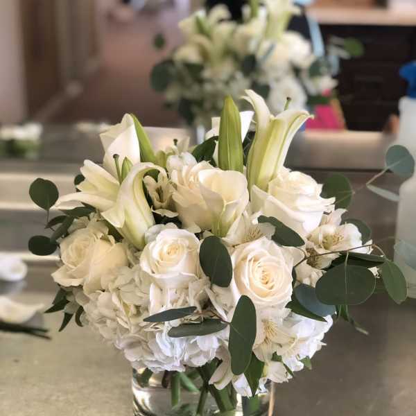 White roses and lilies arranged in a glass vase