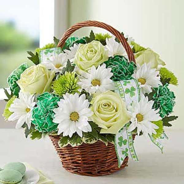 Basket of white daisies and pale yellow roses with green accents