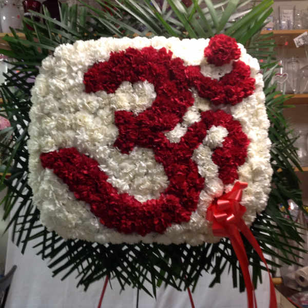 Large red and white floral standing display with a ribbon bow