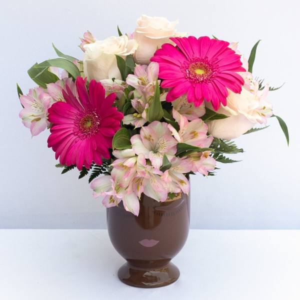 Pink gerbera daisies and white roses in a brown vase
