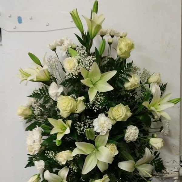 White lilies and roses arranged in a large standing spray