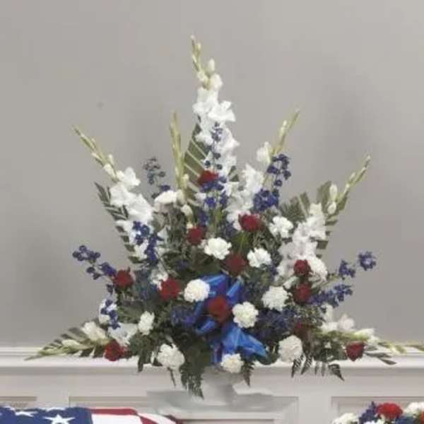 Red, white, and blue floral arrangement in a white vase