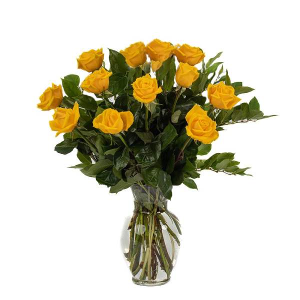 Tall arrangement of yellow roses in a clear glass vase