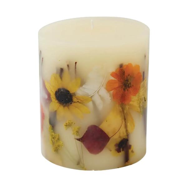 Decorative pillar candle with pressed flowers embedded in wax