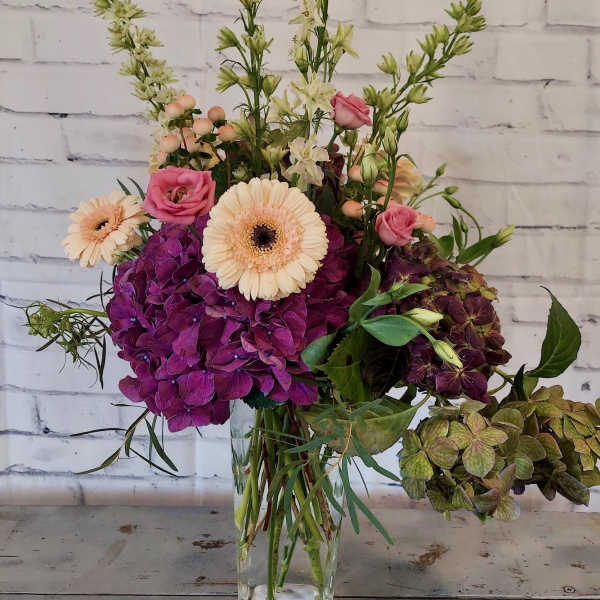 Mixed bouquet in a clear glass vase with pink and cream blooms