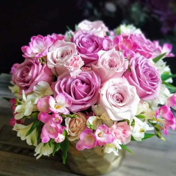 Pink and white rose bouquet in a gold vase
