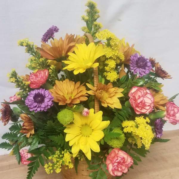 Basket arrangement of yellow, purple, pink, and orange flowers