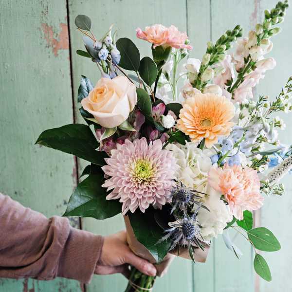 Hand-tied bouquet with peach, pink, and white flowers