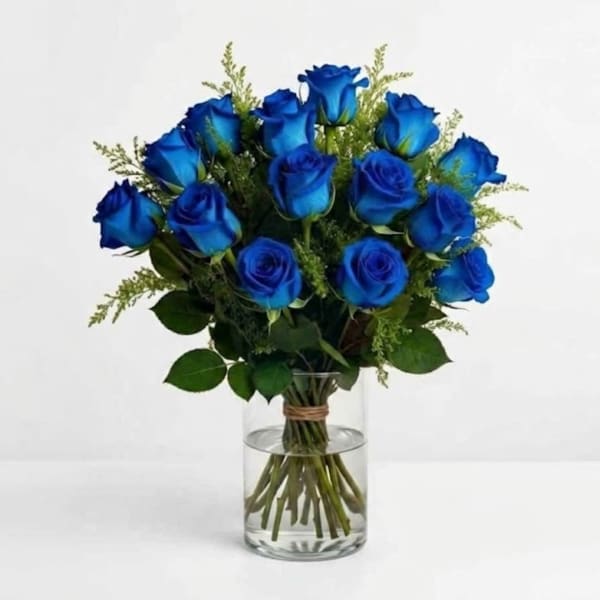 Blue roses arranged in a clear glass vase