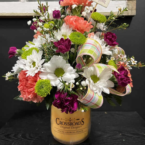 Mixed bouquet in a candle jar with a "Love you Mom" card