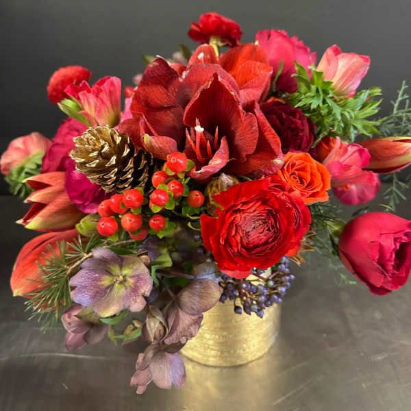 Red and pink floral arrangement in a gold container