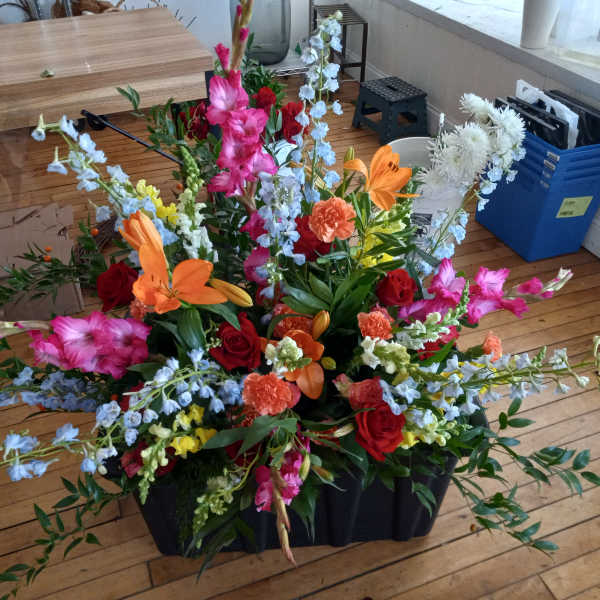 Large mixed floral arrangement with red, pink, orange, and white blooms