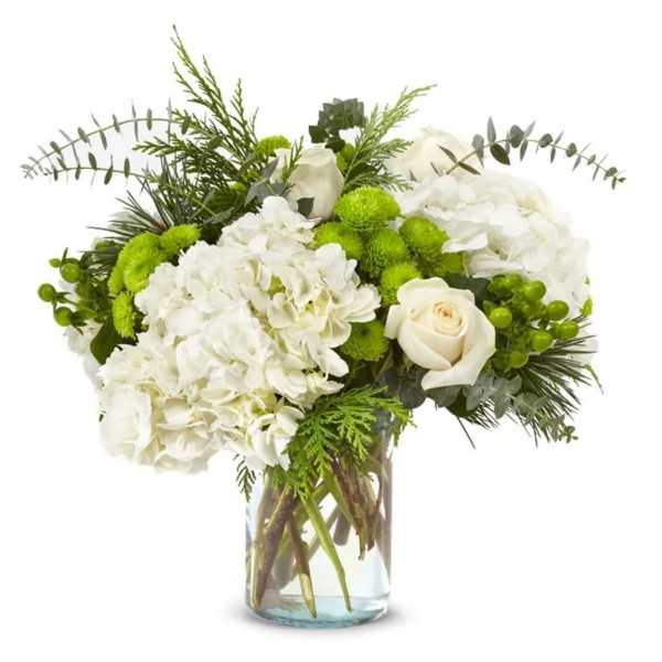 White hydrangeas and roses in a clear glass vase with green accents
