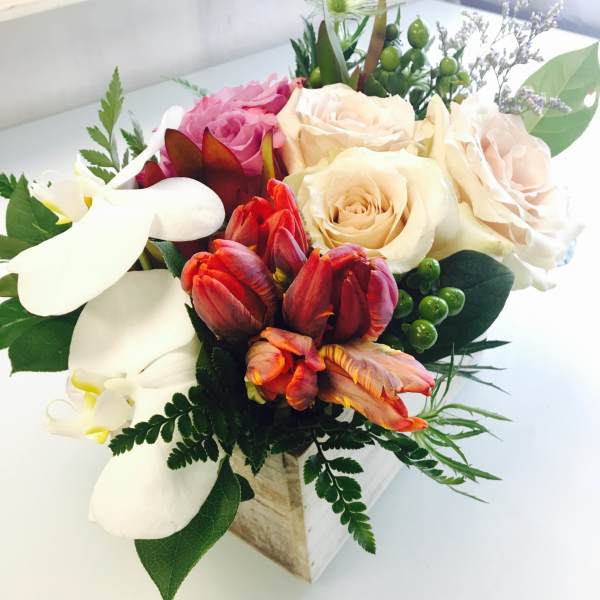 Mixed bouquet with roses, tulips, and white calla lilies in a wooden box