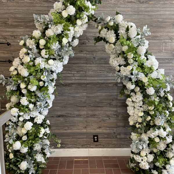 Large white floral arch with roses and hydrangeas