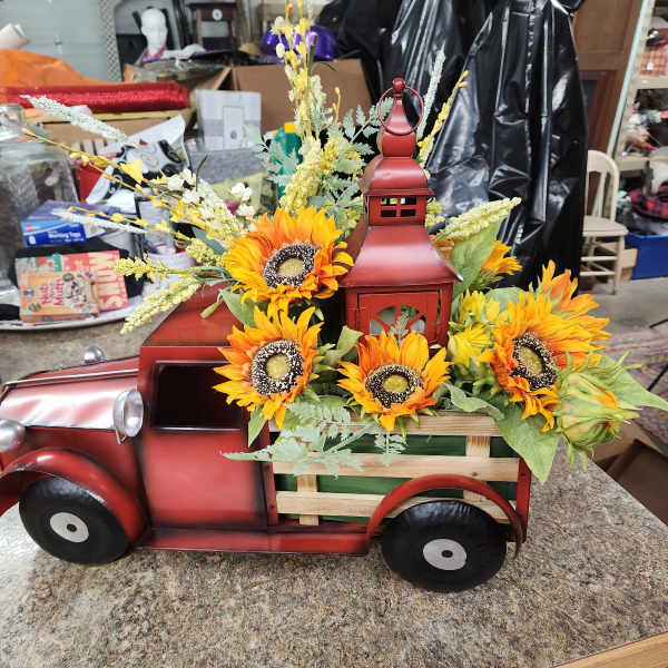 Sunflowers arranged in a red metal truck-shaped container