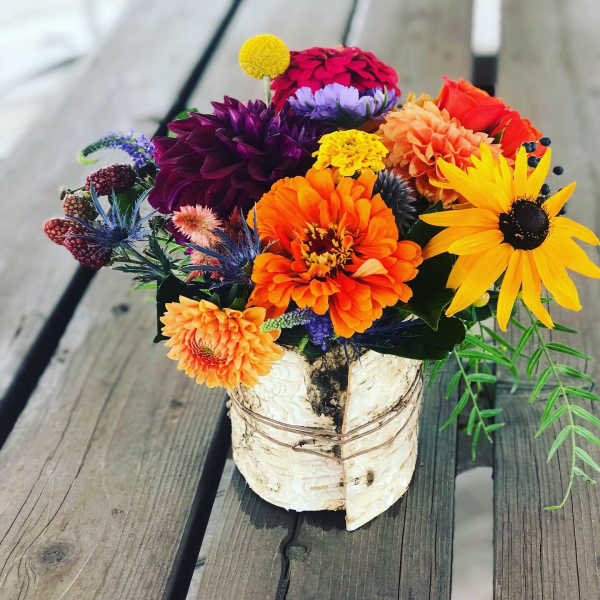 Colorful mixed bouquet in a birch bark container