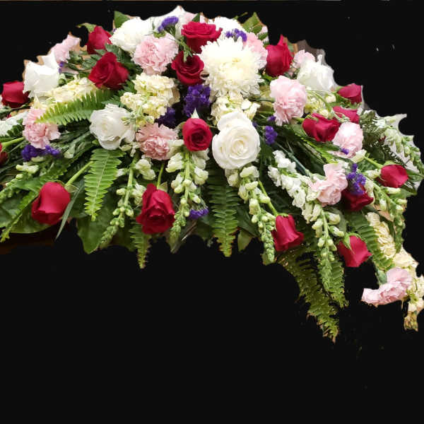 Casket spray with red and white roses, pink carnations, and greenery