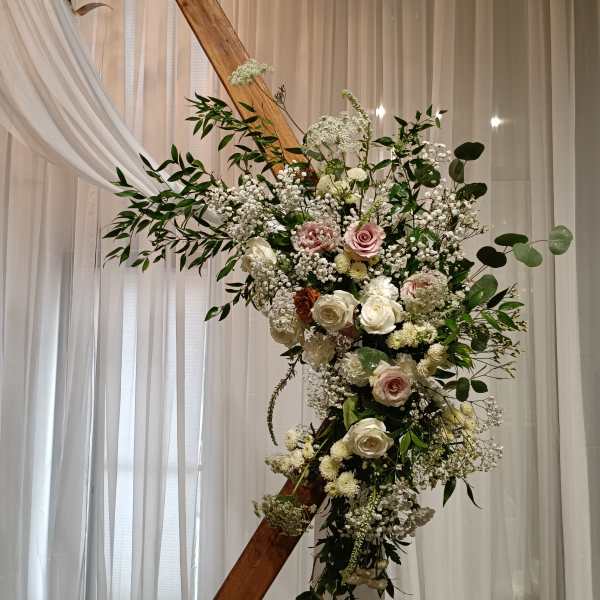 Large floral arrangement with white and blush roses on a wooden frame