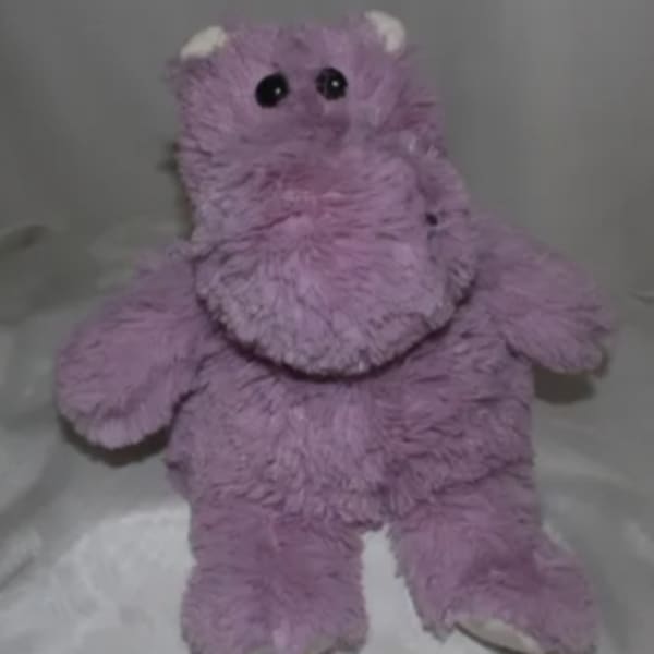 Purple plush teddy bear with black eyes and white paws