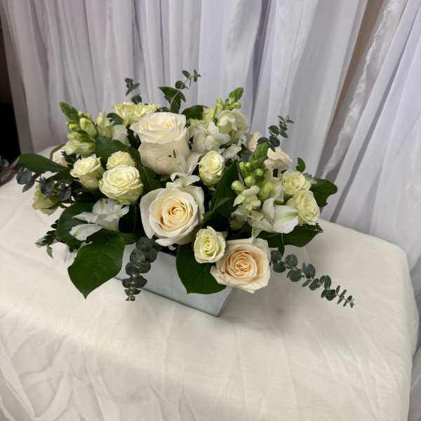 White rose bouquet with eucalyptus in a square vase