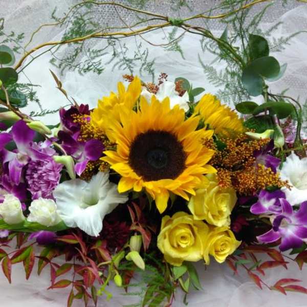 Mixed bouquet with a sunflower, yellow roses, and purple orchids