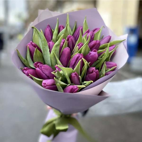 Bouquet of purple tulips wrapped in lavender paper