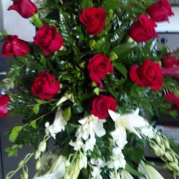 Tall standing arrangement of red roses and white lilies