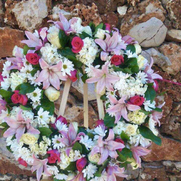 Heart-shaped floral wreath with pink lilies, roses, and white daisies