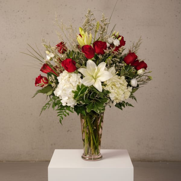 Red roses and white lilies arranged in a clear glass vase