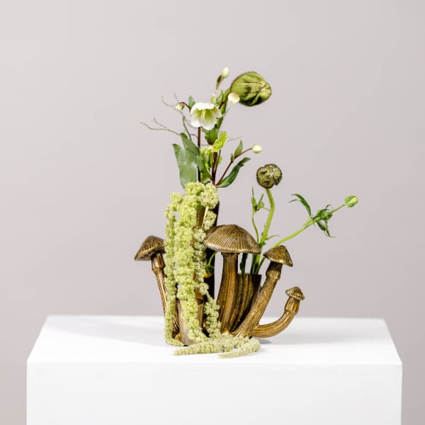 Small floral arrangement in a gold mushroom-shaped vase