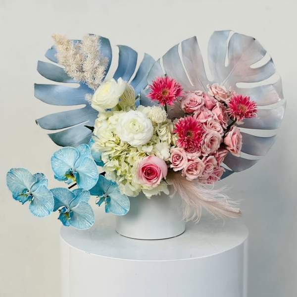 Pastel floral arrangement with pink and white blooms in a white vase