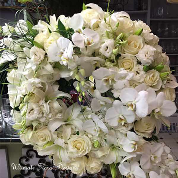 Large white floral wreath with roses and orchids