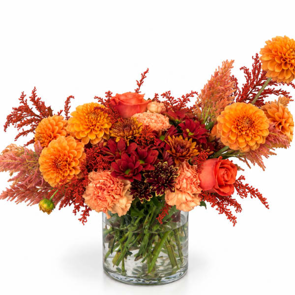 Orange and red mixed bouquet in a clear glass vase