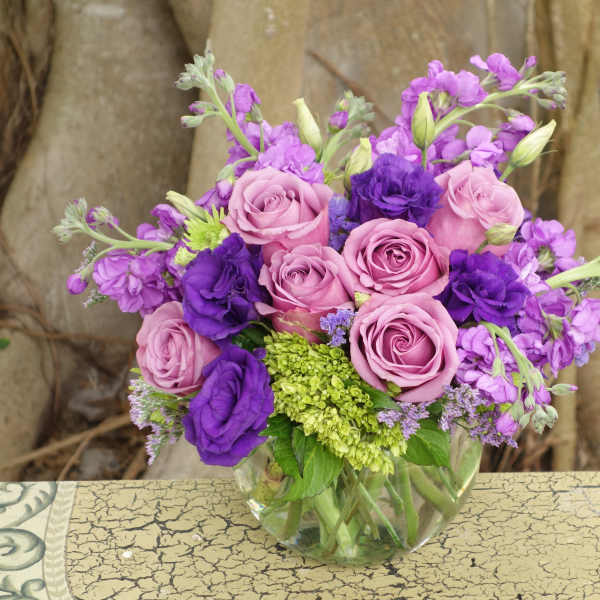Pink and purple rose bouquet in a clear glass vase