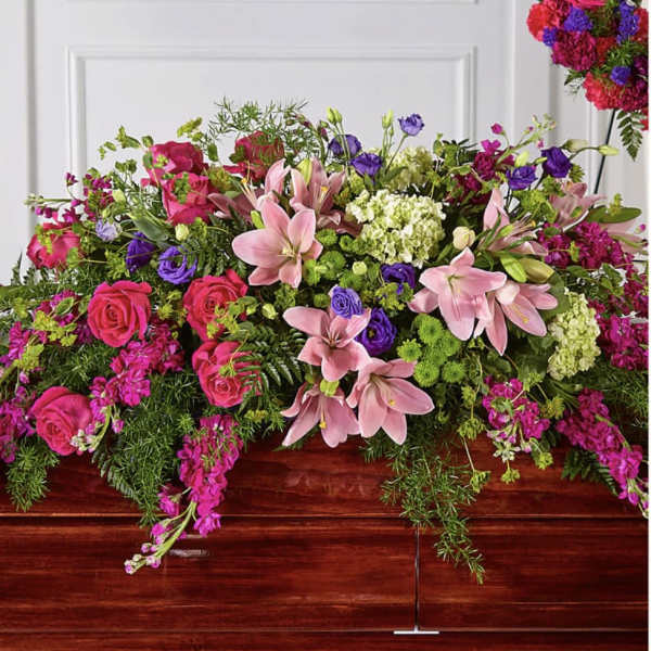 Large casket spray with pink lilies, roses, and purple flowers