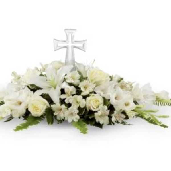 White floral casket spray with a clear cross centerpiece