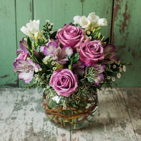 Pink roses and purple alstroemeria in a glass vase