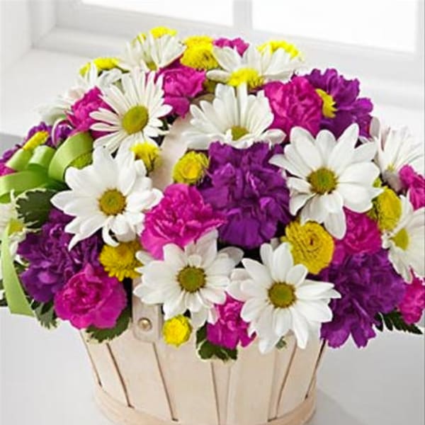 Basket of white daisies, pink carnations, and purple flowers
