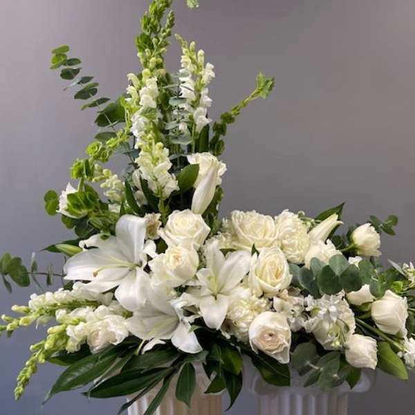 White floral arrangement with lilies and roses in a vase