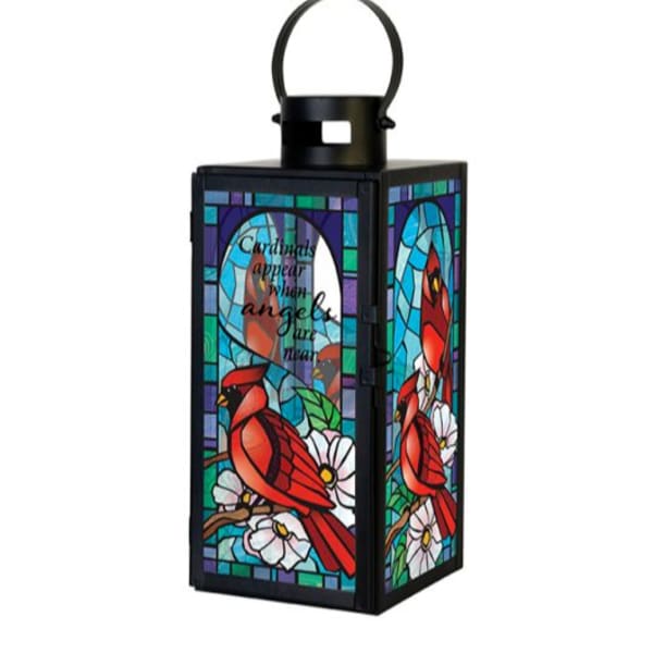 Black metal lantern with stained-glass cardinal and white flowers in bright jewel tones.