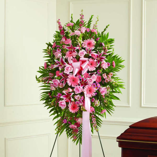 Pink floral standing spray on an easel with a ribbon