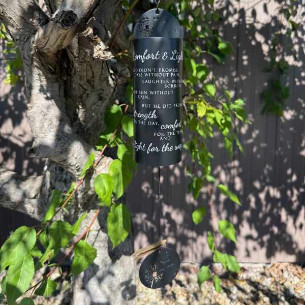 Black memorial wind chime hanging from a tree