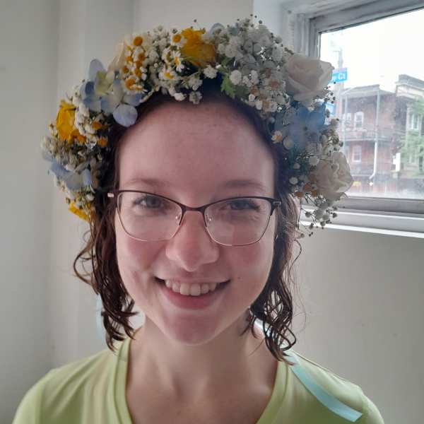Woman wearing a floral crown of white, yellow, and blue flowers