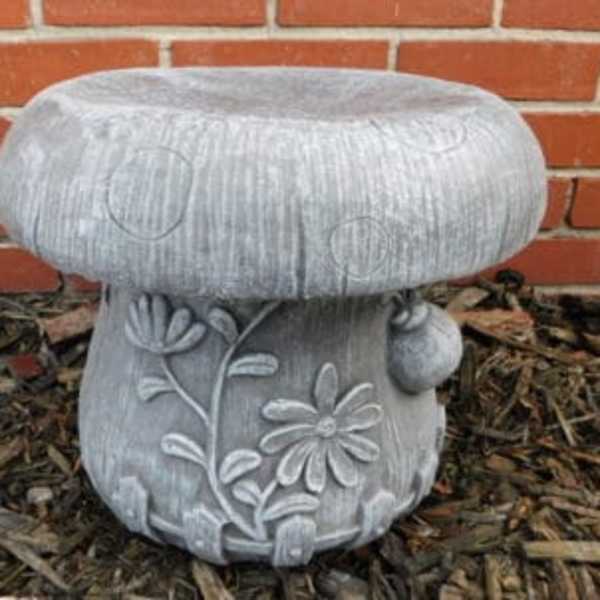 Gray mushroom-shaped garden stool with floral relief details