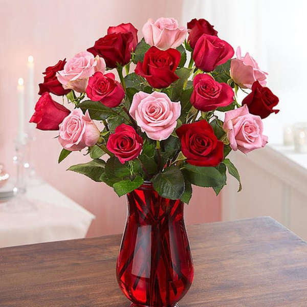 Bouquet of red and pink roses in a red glass vase