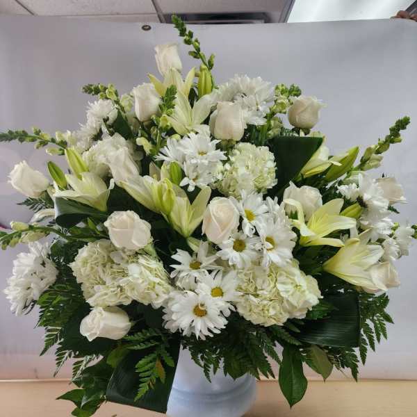 White roses, lilies, daisies, and hydrangeas in a white vase