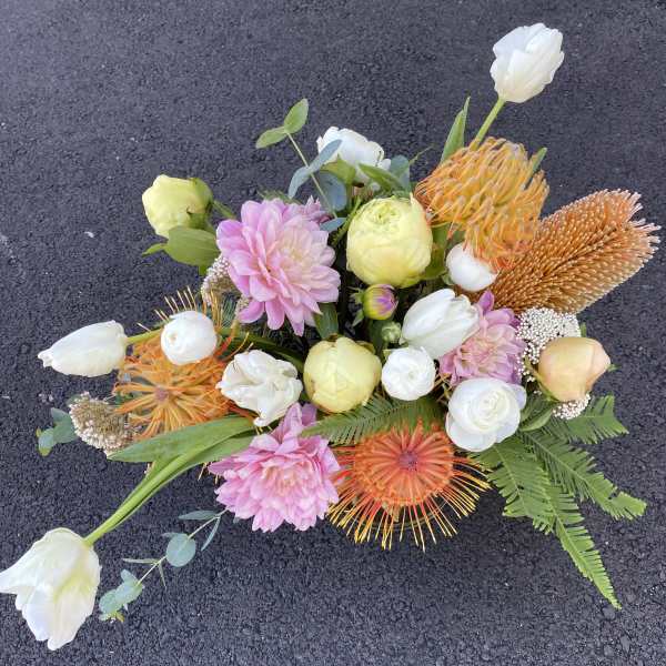 Mixed bouquet with pink, white, and orange flowers on a dark surface
